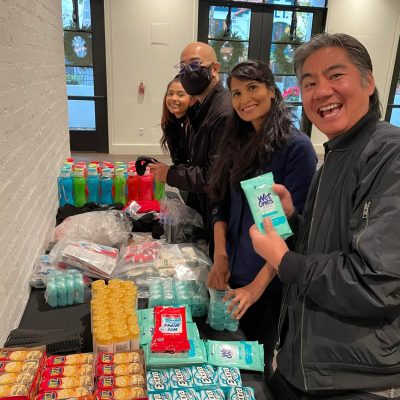 Team members organizing essential items for disaster relief care kits during the Team Disaster Relief event. They are collaboratively preparing supplies, including snacks and hygiene products, to support recovery efforts.