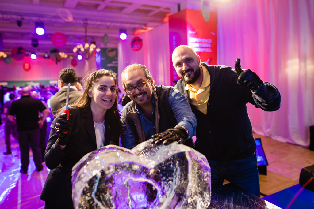 A group proudly showcases their completed ice sculpture during a Team building Ice Sculpting event, celebrating their teamwork and creativity.