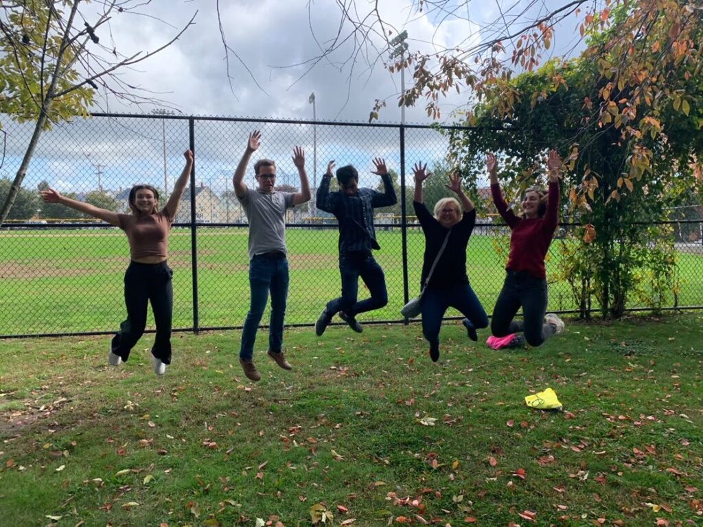 A group of participants joyfully jumping in the air during the Healthcare Heroes scavenger hunt team building activity.