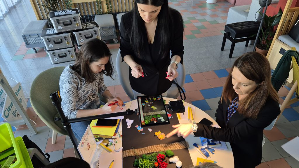 Stop motion animation team building activity. Participants work together to create scenes and adjust props frame by frame, showcasing creativity, teamwork, and collaboration in crafting a short animated film.