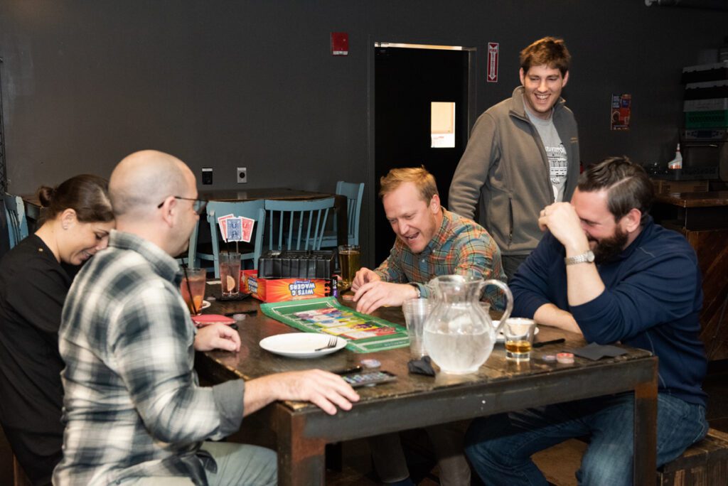 Team members share a moment of laughter while playing a board game during a lively team building networking event.