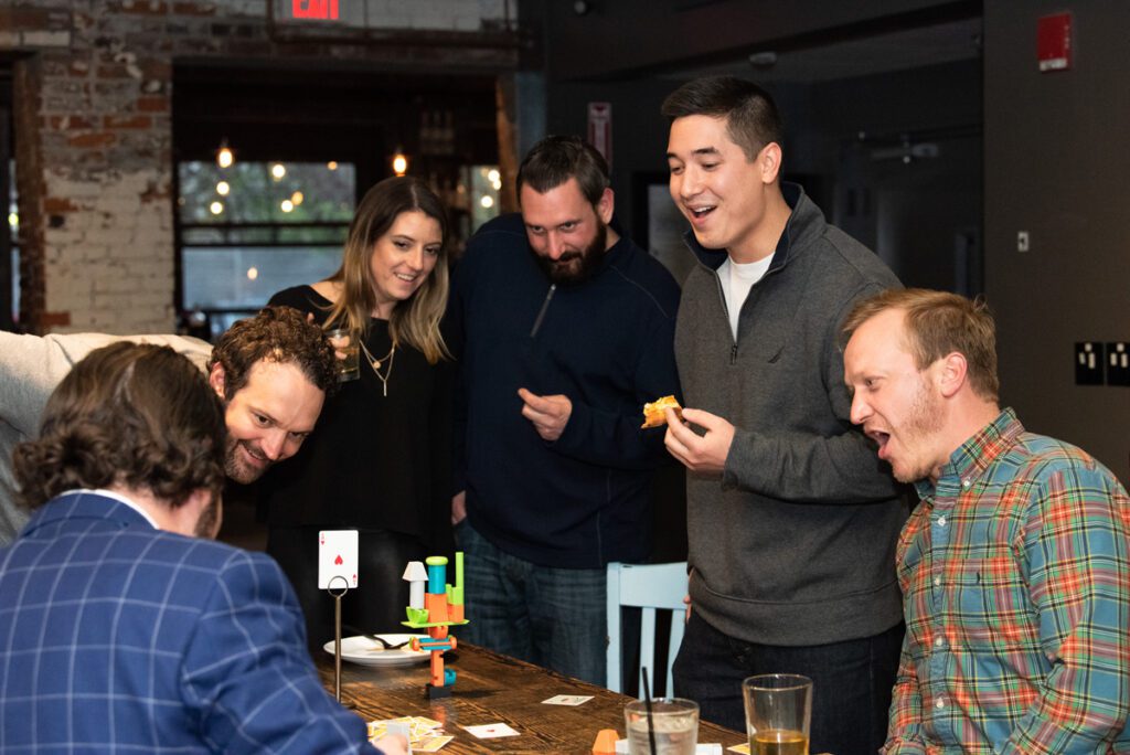 Participants enthusiastically engage in a fun and competitive board game during a team building networking event.