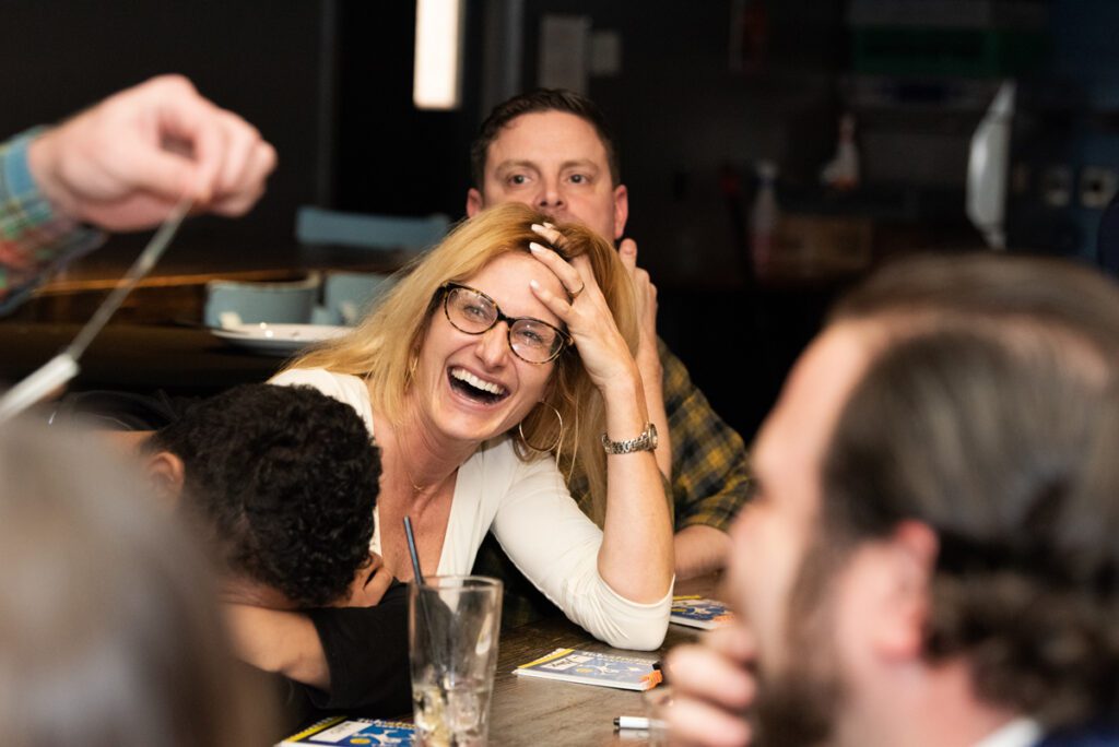 A participant laughs and enjoys the team building game during a fun and engaging networking event, fostering connections through playful interaction.