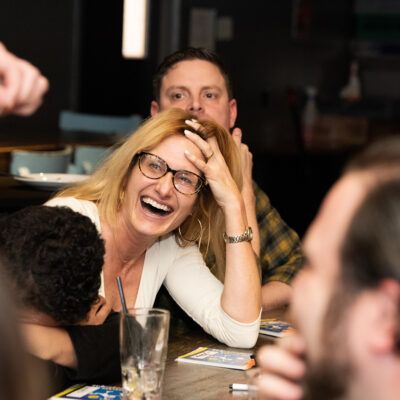 A participant laughs and enjoys the team building game during a fun and engaging networking event, fostering connections through playful interaction.