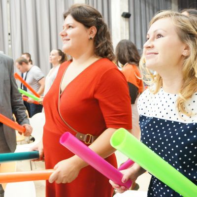 Team members actively participating in Boom Time, a musical team building activity. They collaborate with colorful Boomwhackers to create music, fostering teamwork, energy, and communication.