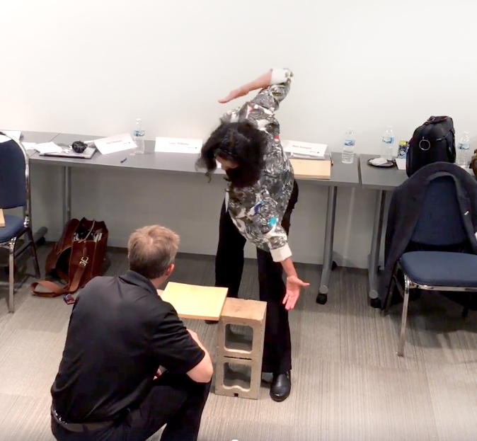 A participant prepares to break a board during a transformational team building activity, symbolizing the act of overcoming personal and professional obstacles.