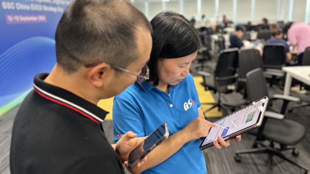 This image captures two participants engaged in a team building activity, where they collaborate using tablets to analyze or solve challenges related to their AI-driven news broadcast creation task.