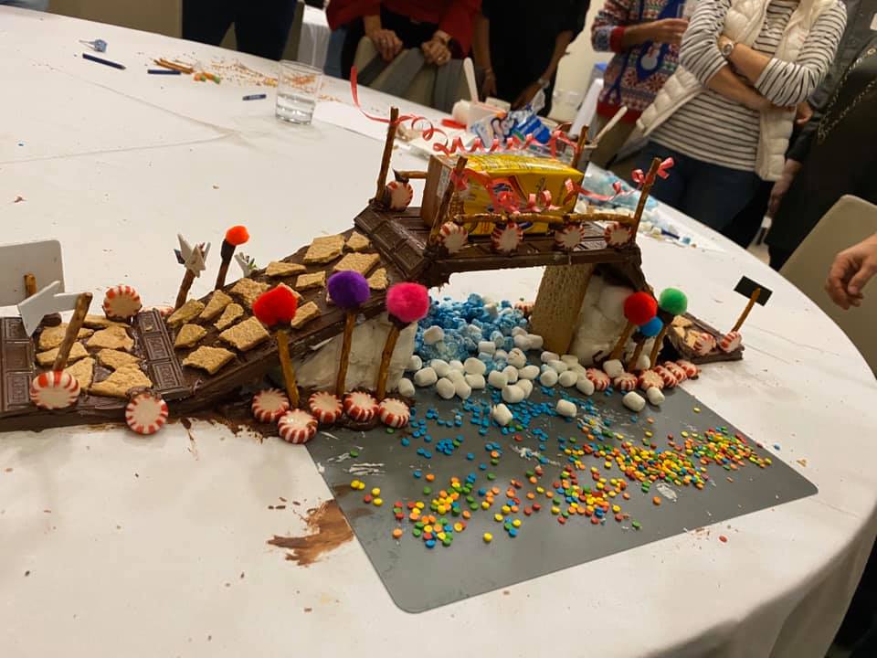 A detailed chocolate bridge created during The Chocolate Challenge team building event. The bridge is decorated with graham crackers, candy, and colorful sprinkles, showcasing creativity and teamwork.