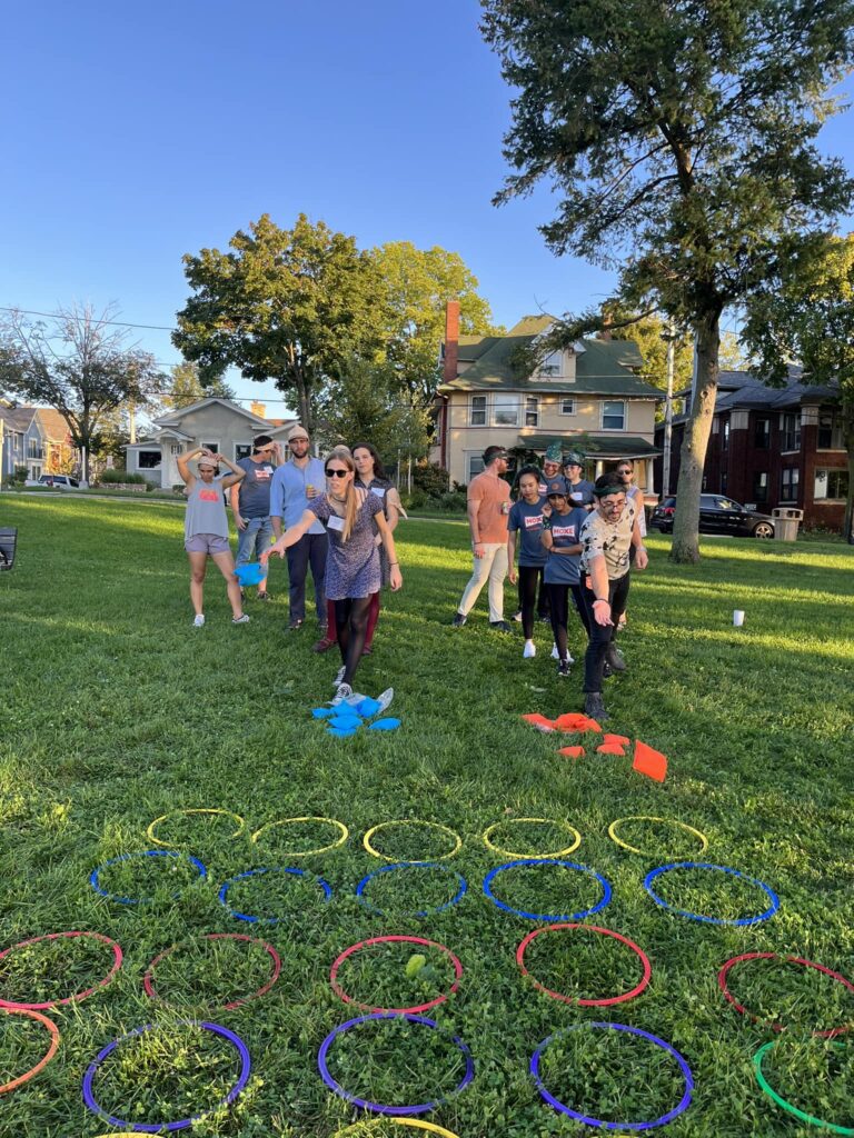 Team members participate in a hoop relay challenge during the Corporate Survivor team building event, focusing on coordination and teamwork.