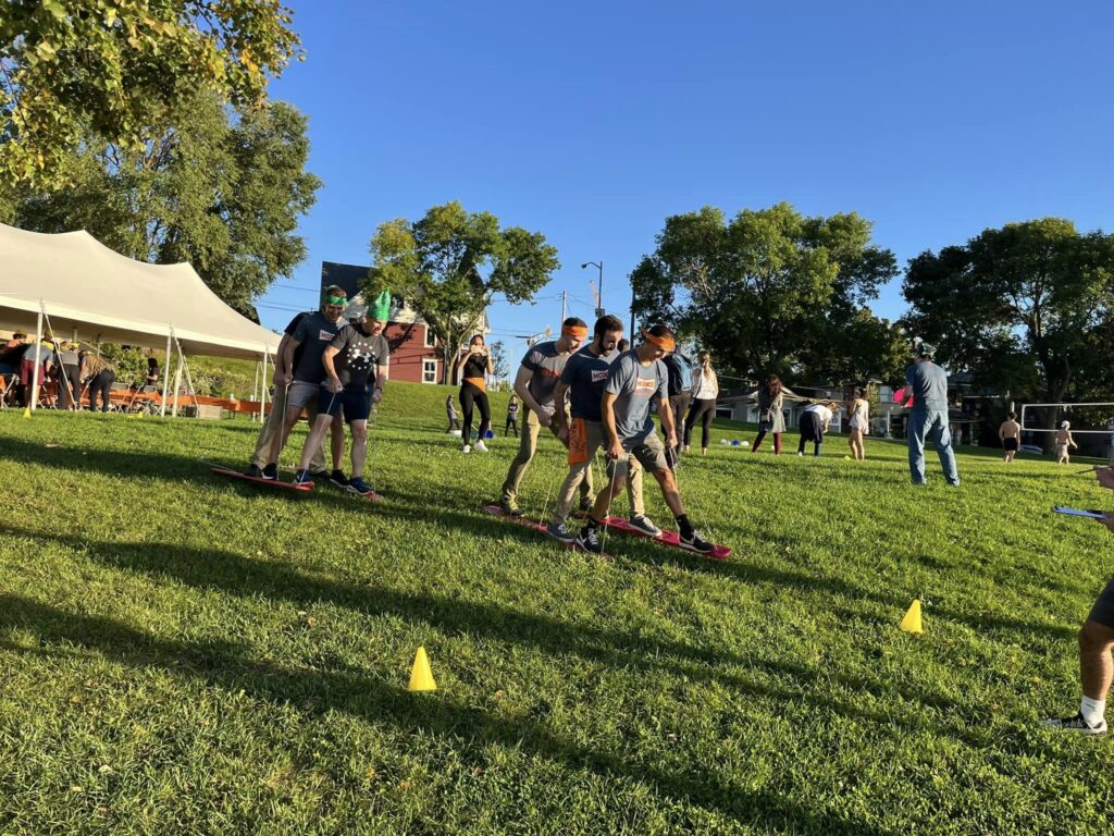 Teams work together on a multi-person ski challenge during an outdoor team building event.