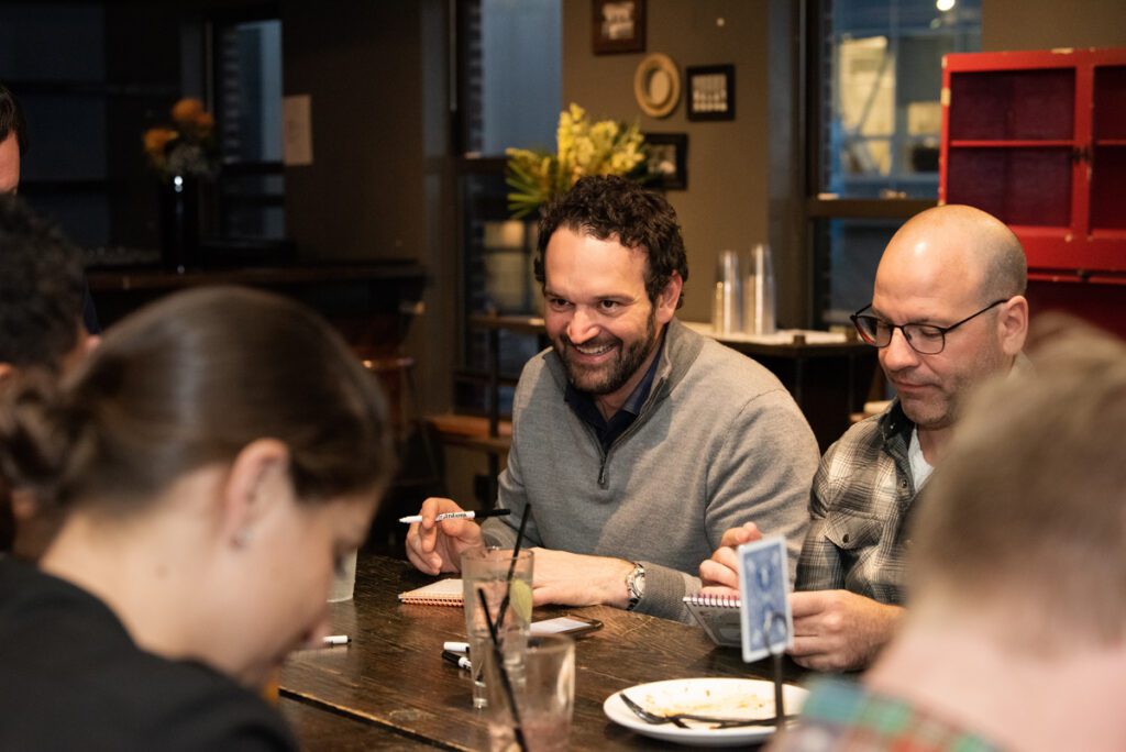 Team members enjoy a lively conversation while participating in a team building networking game at a casual event.