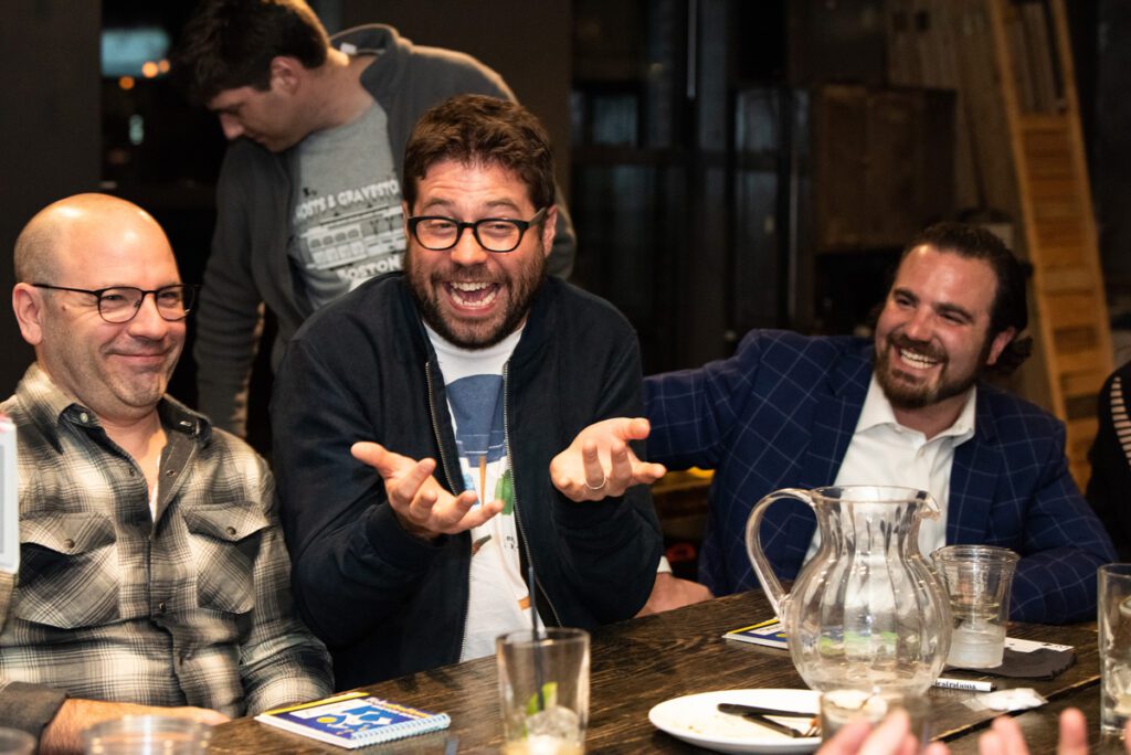 Two team members laugh together while participating in an engaging board game at a team building networking event.