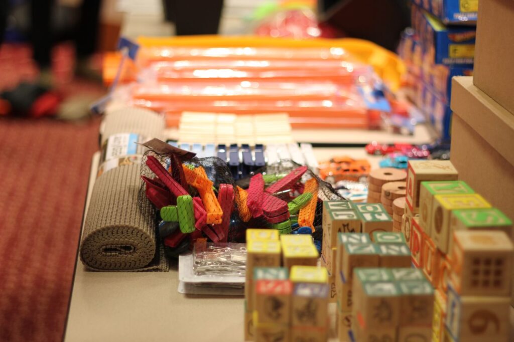 A table filled with colorful materials and building blocks, prepared for the Domino Effect team building activity.