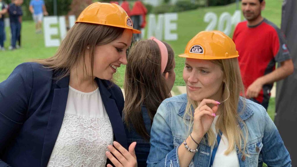 Outdoor team building activity promoting collaboration and communication. Two participants wearing hard hats engage in a discussion, emphasizing teamwork and strategic problem-solving in a fun setting.