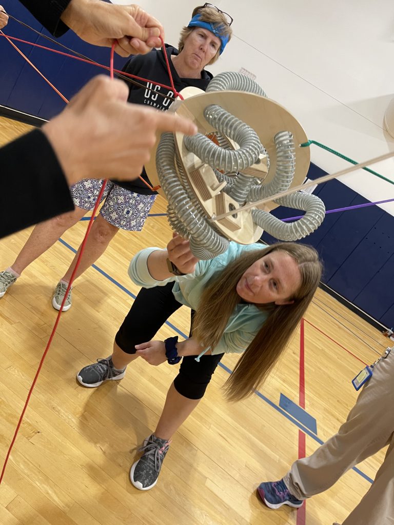 A participant carefully adjusting a mechanical structure during the Integrity team building event, showcasing focus and teamwork.