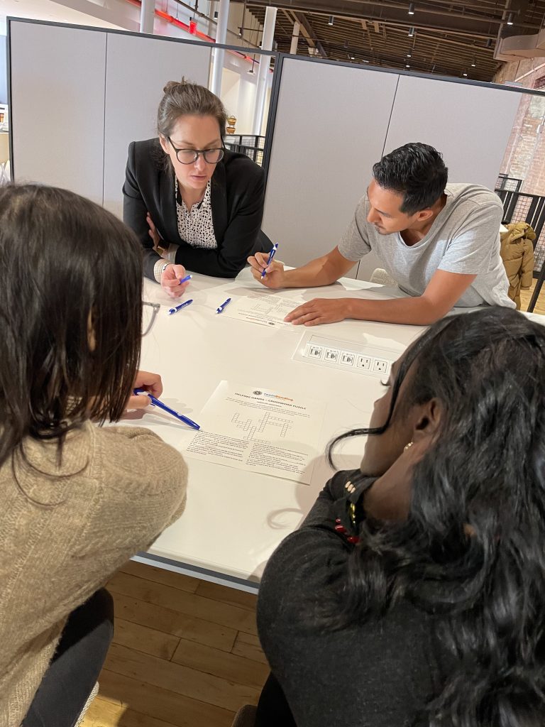 Team members collaborating and problem-solving during the Team Disaster Relief event, working together to plan and assemble disaster relief care kits. The activity emphasizes teamwork and communication skills.