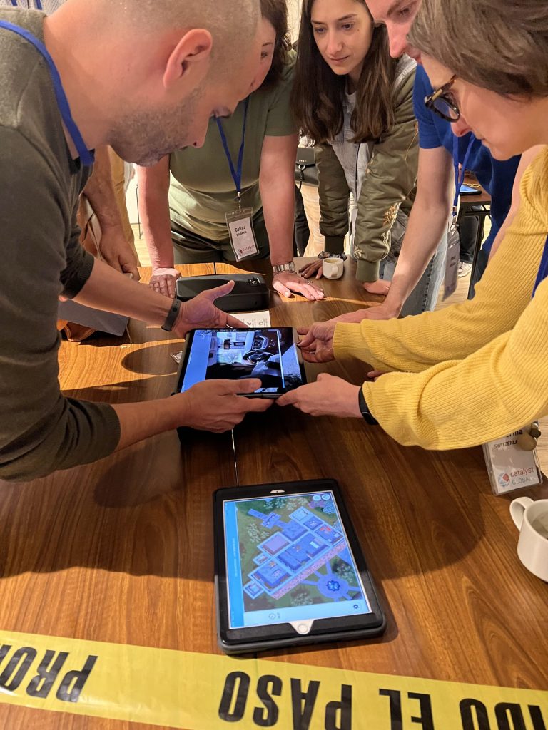 Team members collaborating and using tablets to explore evidence in the interactive 3D crime scene of the Corporate CSI team building event.