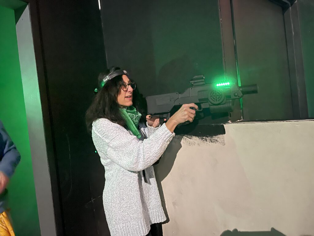 Participant enjoys a laser tag adventure during The Mystery Bus team building event, featuring surprise destinations and fun activities.