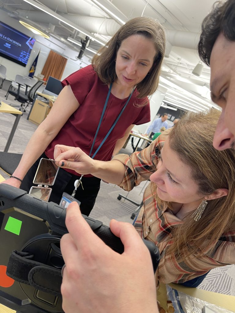 Group of colleagues reviewing evidence and analyzing a tablet during the Corporate CSI team building event.