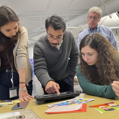 Participants collaborate while analyzing evidence on a tablet during the Corporate CSI team building event.