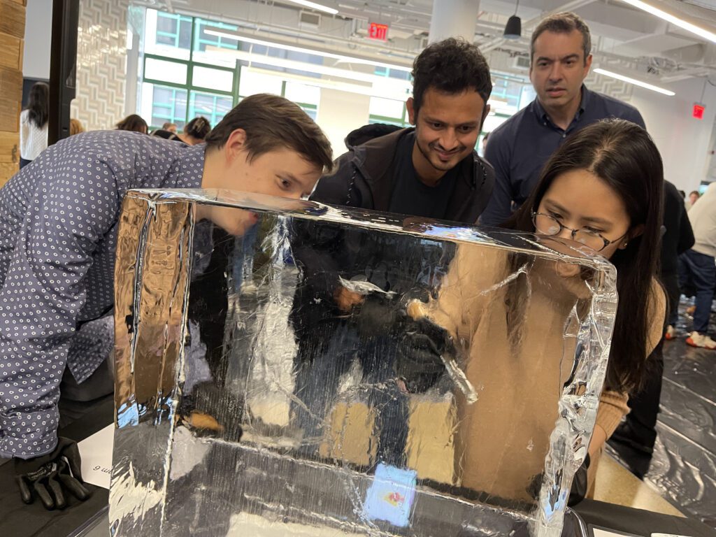 Participants focused on sculpting a block of ice during a Team building Ice Sculpting event, collaborating to create impressive works of art.