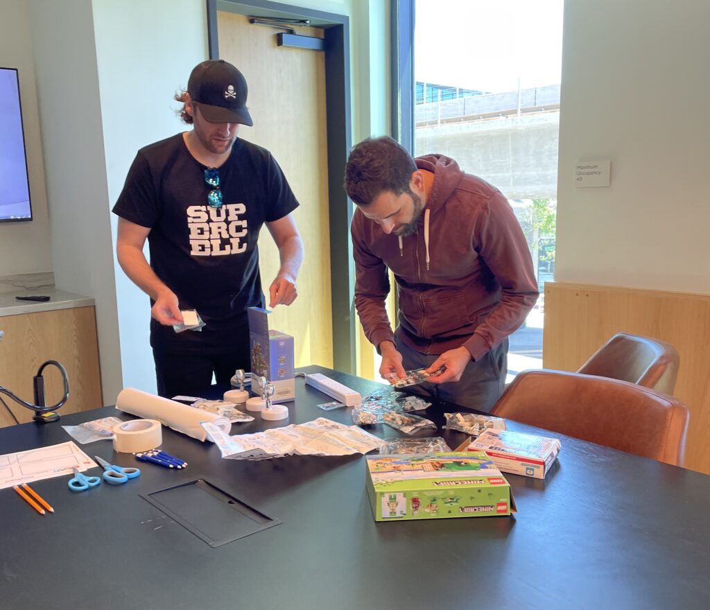 Two participants organizing materials and planning for their stop motion animation project during a team building event.