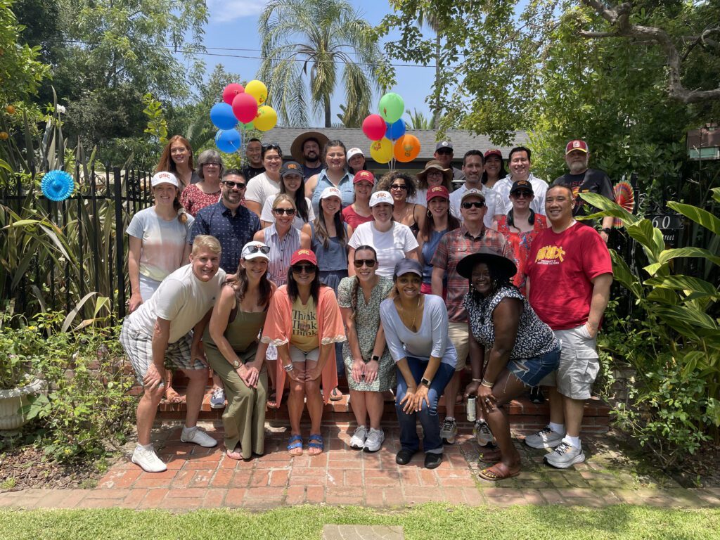 A happy group posing together outdoors during a fun and colorful team building event.