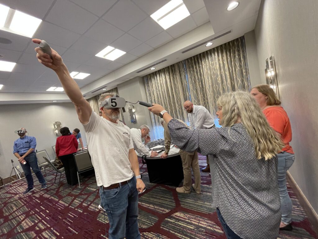 articipants wearing VR headsets collaborate in The Infinite Loop team building event, engaging in hands-on problem-solving tasks that require strong communication and teamwork.