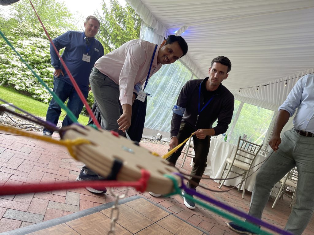 Participants working together in the Integrity team building event, using colorful ropes to complete a physical challenge while focusing on collaboration.