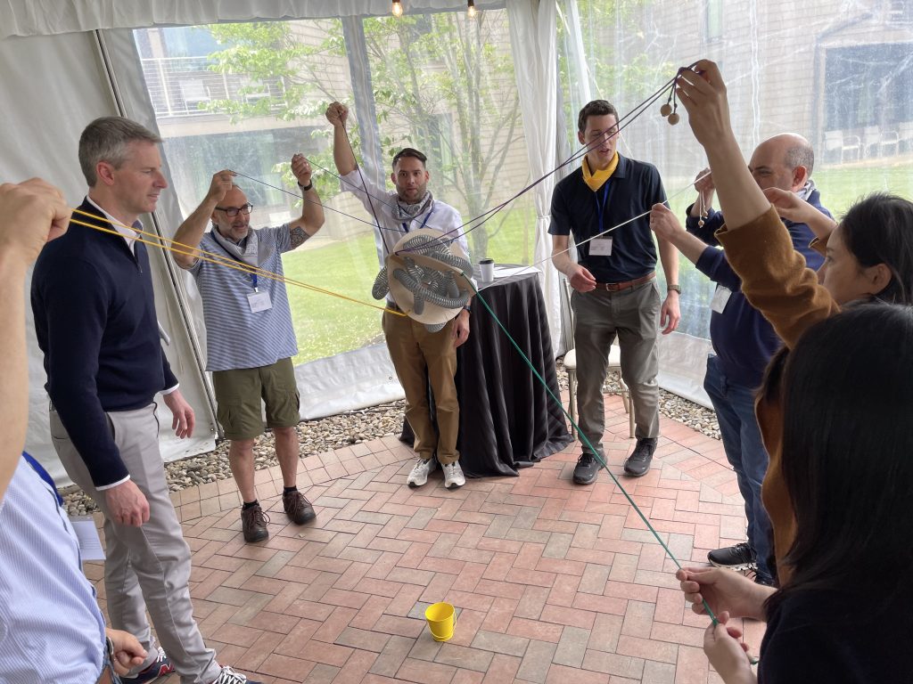 Participants working together in the Integrity team building event, using ropes and coordination to complete a group challenge.