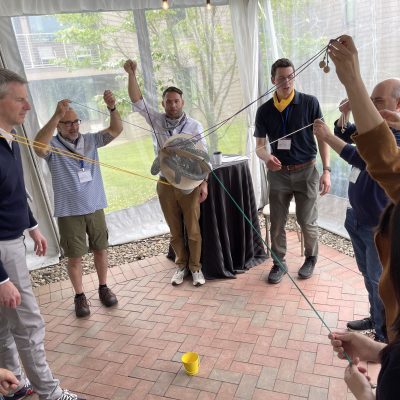 Participants working together in the Integrity team building event, using ropes and coordination to complete a group challenge.