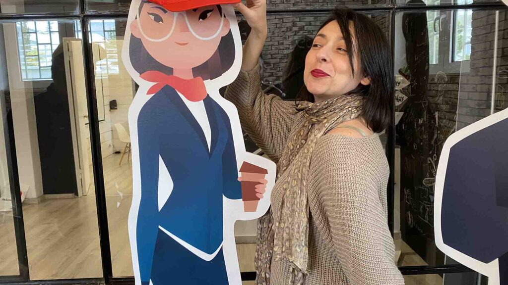 A team member enjoying a fun moment during the Leadership Stories event, posing next to a character cutout from the game.