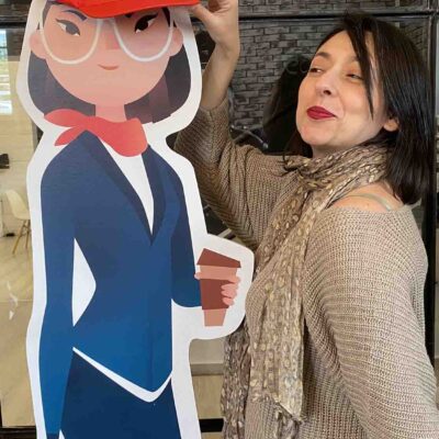 A team member enjoying a fun moment during the Leadership Stories event, posing next to a character cutout from the game.