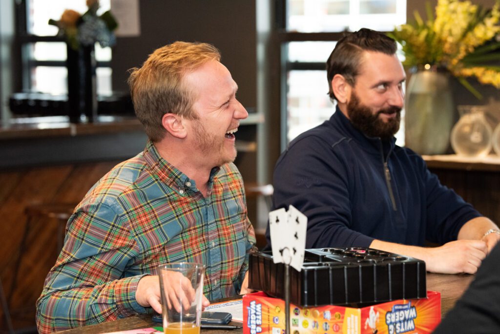 Two participants share a lighthearted moment while enjoying a board game during a team building networking event.