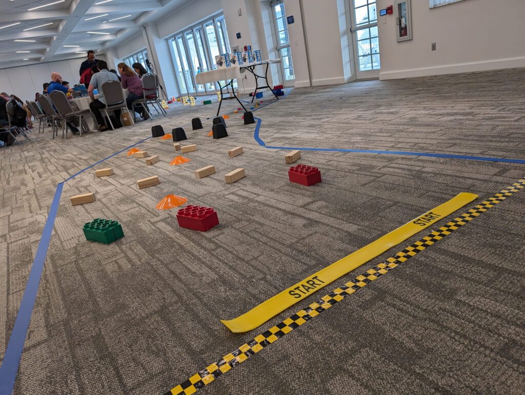 A course is set up indoors on a carpeted floor, marked with a yellow 