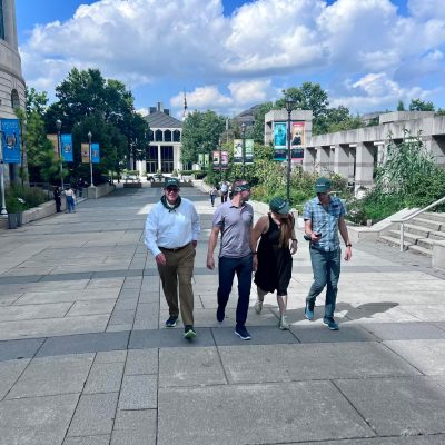 Team exploring an outdoor museum during a scavenger hunt. Participants collaborate to solve challenges, navigate clues, and engage in a fun team building experience that promotes problem-solving and teamwork.