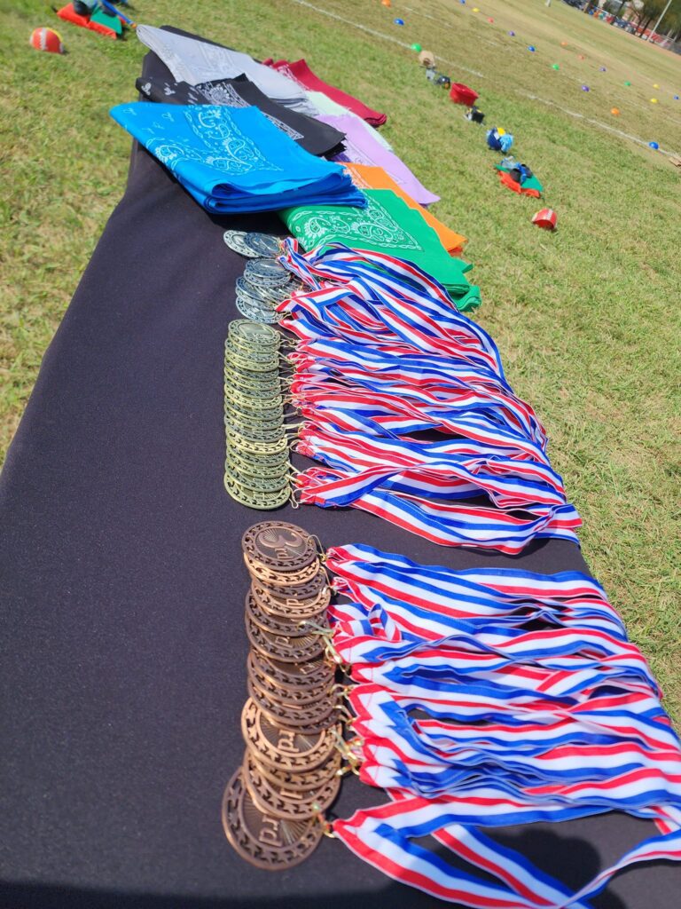 Medals and team flags displayed at an Outrageous Games team building event, ready for the award ceremony after a day of fun challenges.