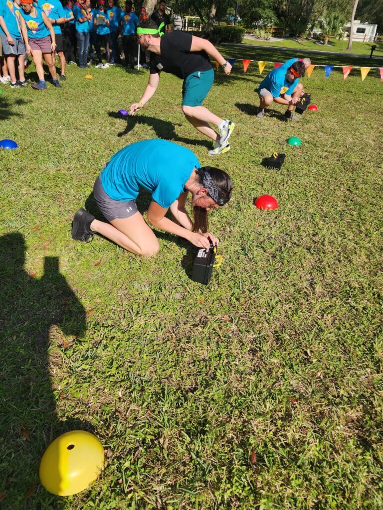 Participants work together to unlock a challenge during the Outrageous Games team building event, promoting teamwork and critical thinking.