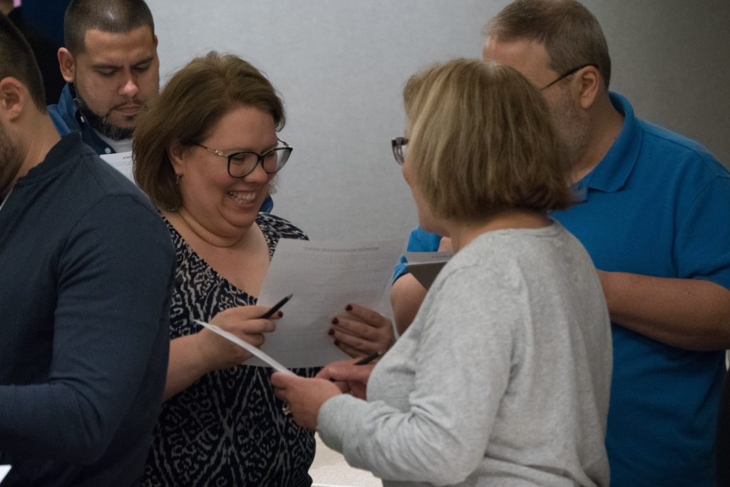 Team members engaging in a discussion during the Team and Leadership DNA event, exchanging insights from their Belbin® Team Roles profiles to enhance collaboration and understanding of individual strengths and weaknesses.