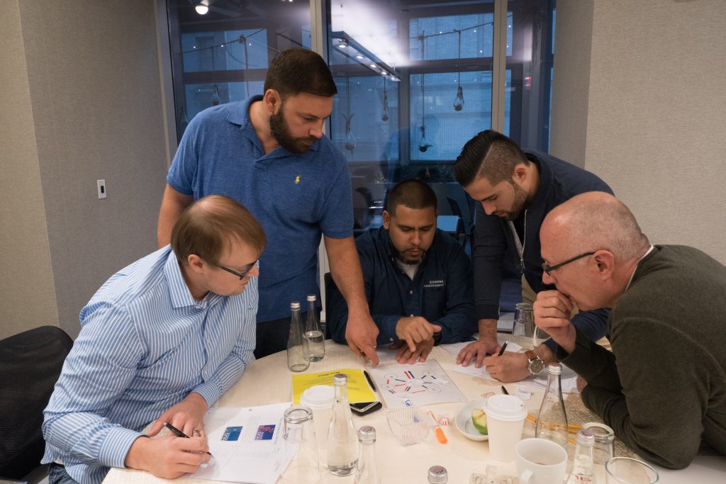 A group of participants collaborating during the Team and Leadership DNA session, analyzing data and discussing insights to improve team dynamics and leadership effectiveness.