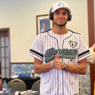 Participants actively engaging in the Sound Crowd event, wearing silent headphones, with one person in a baseball jersey smiling and clapping, while another gestures in the background.