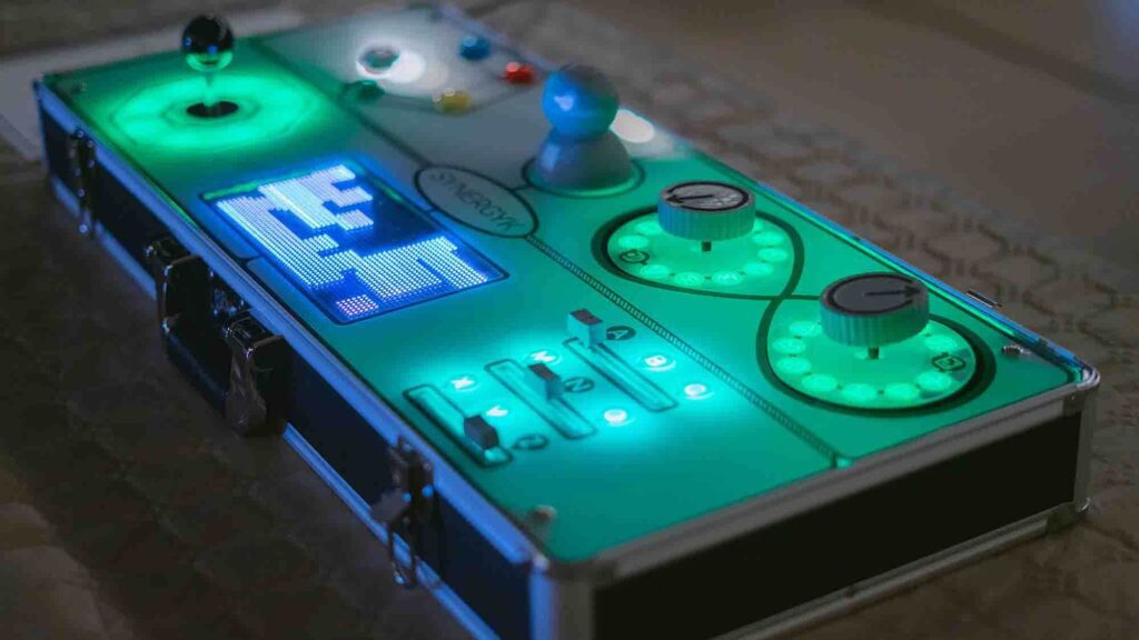 Close-up of a glowing Team Synergy retro gaming console with joysticks, buttons, and sliders, ready for a team building mini-game challenge.