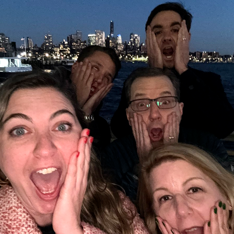 Team members mimic the iconic 'Home Alone' face while enjoying a fun and memorable moment during the Pub Crawl Scavenger Hunt with a stunning cityscape in the background.