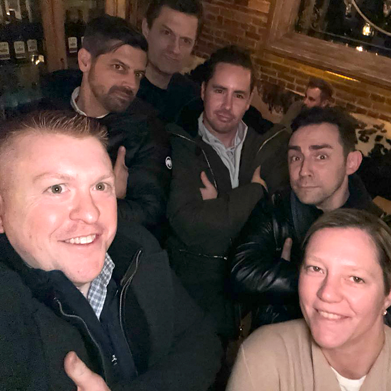 Team members pose confidently during a Pub Crawl Scavenger Hunt, enjoying the camaraderie and lighthearted competition of the event.